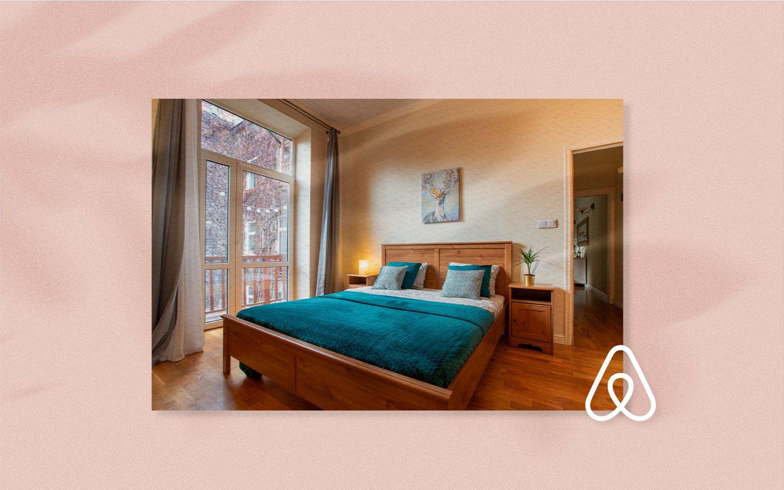 Una camera da letto accogliente con un letto in legno, biancheria da letto color verde acqua, un comodino e un quadro sopra il letto. Una grande finestra con tende fa entrare la luce naturale. Un logo Airbnb dell'agenzia web SHM è nell'angolo in basso a destra.